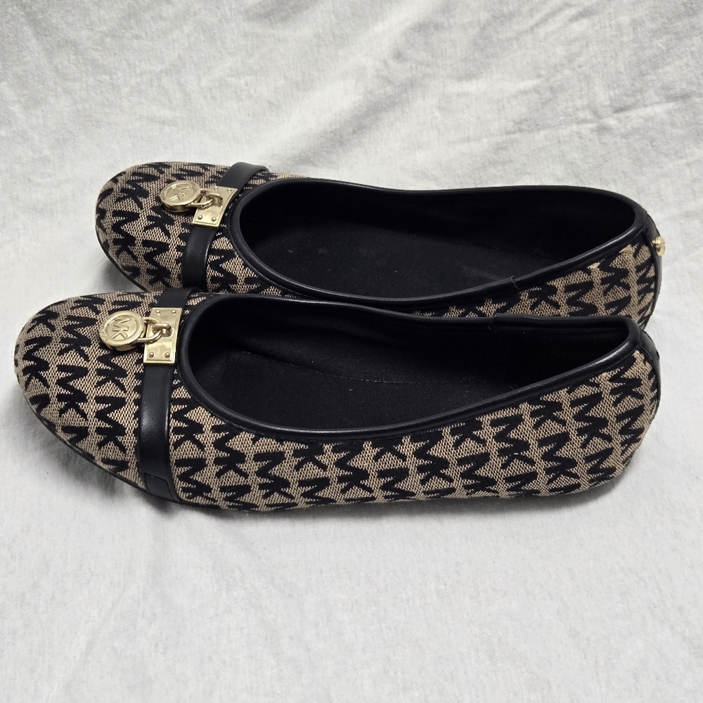 Michael Kors Freeda Tan/Black Monogram Ballet Flats with a gold metal logo.